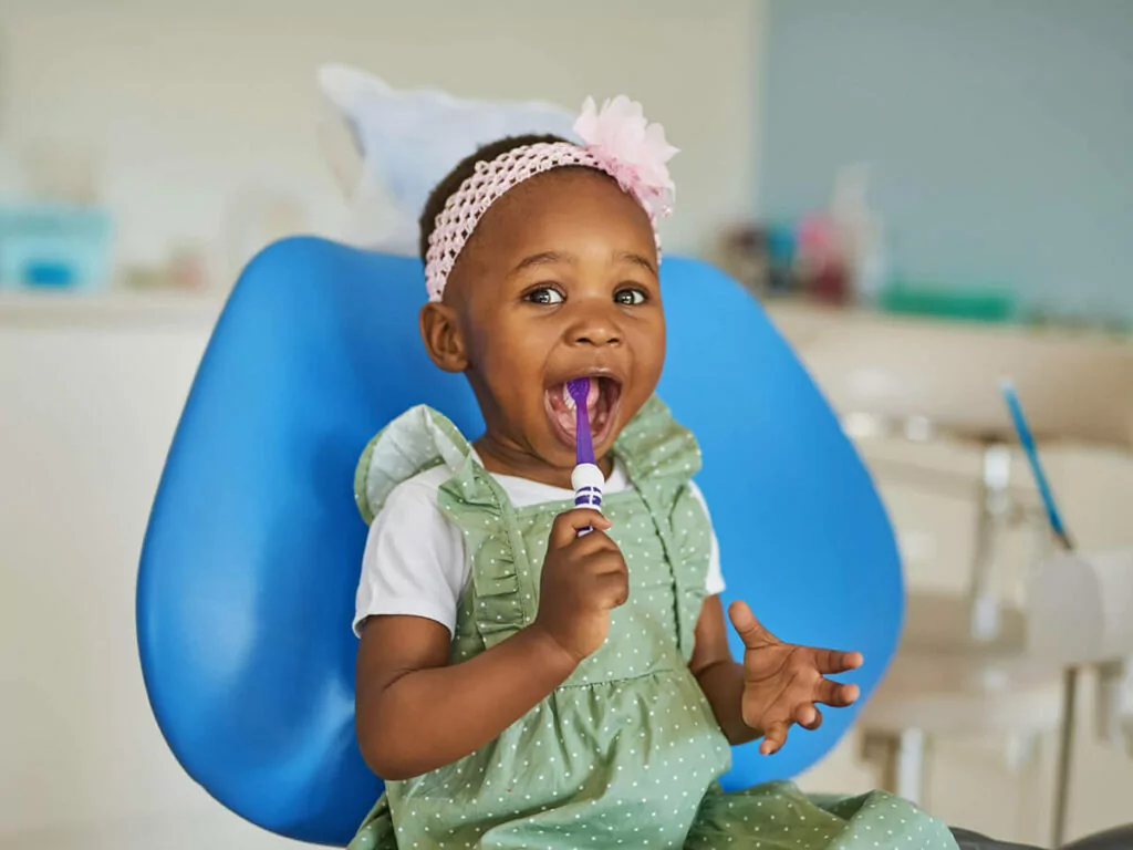 picture of girl with toothbrush in dental chair