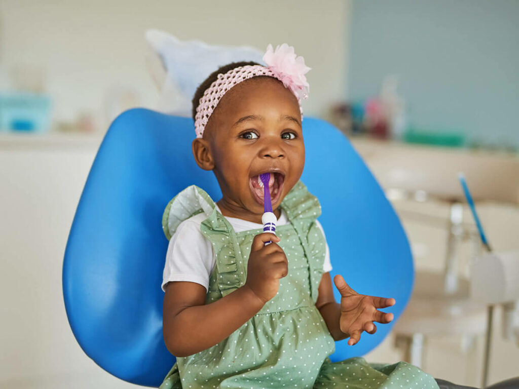 picture of girl with toothbrush in dental chair